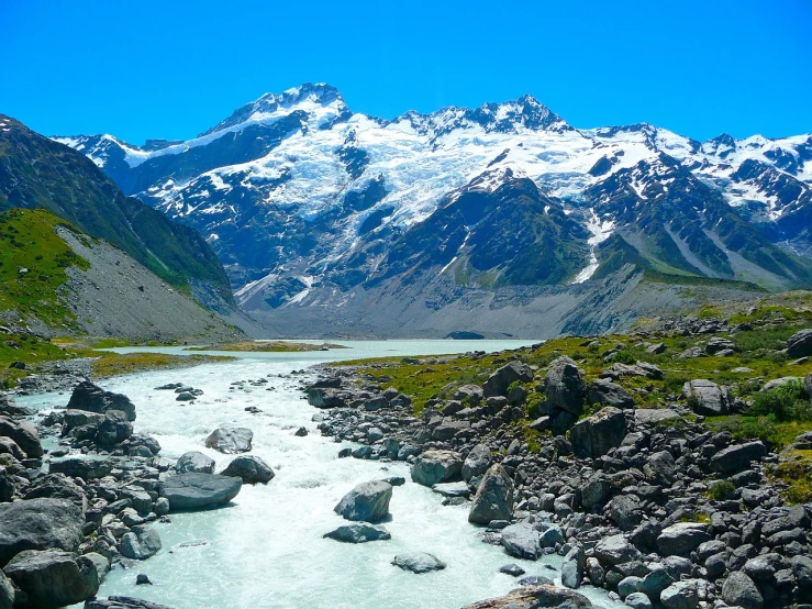 a very pretty stream surrounded by snowy mountains