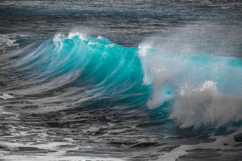 a blue wave with lots of water flying up