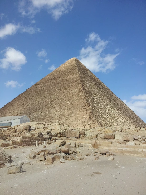 the pyramid that is in the desert under blue sky