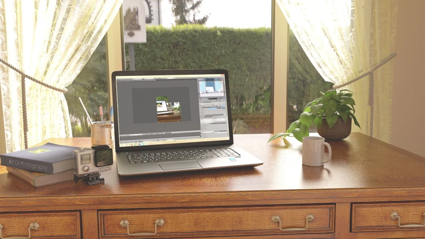 an open laptop on top of a wooden desk