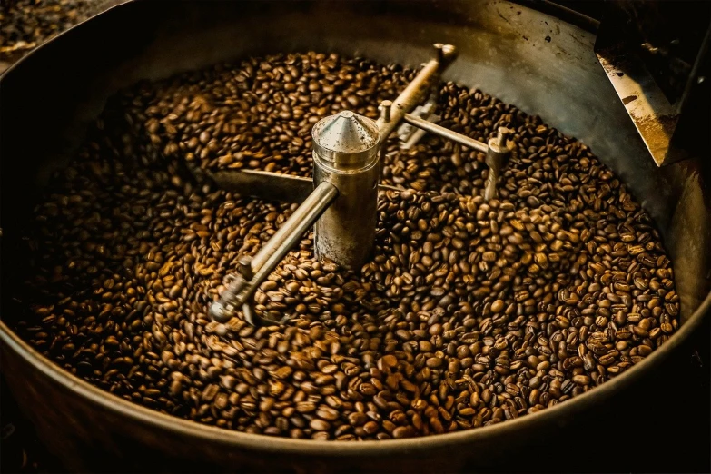 a coffee mill sitting on top of a pile of beans