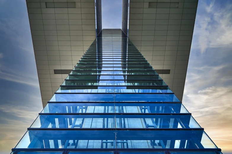 a glass staircase going down to the top of an office building