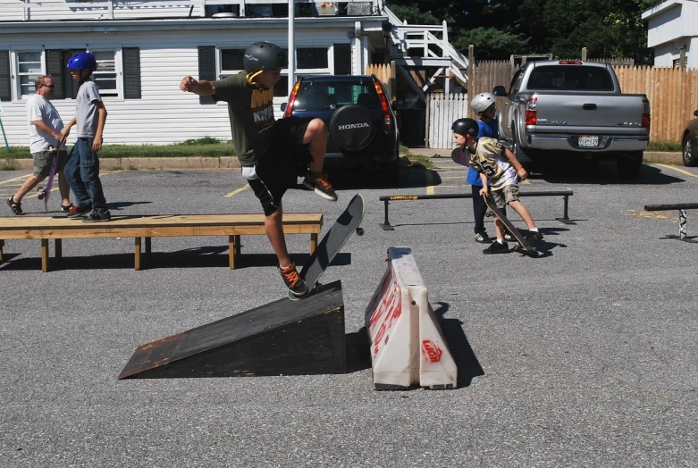 a group of s and a man doing tricks on their skateboards