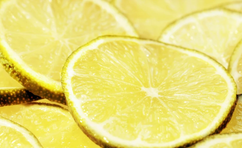 a yellow background has sliced lemons on it