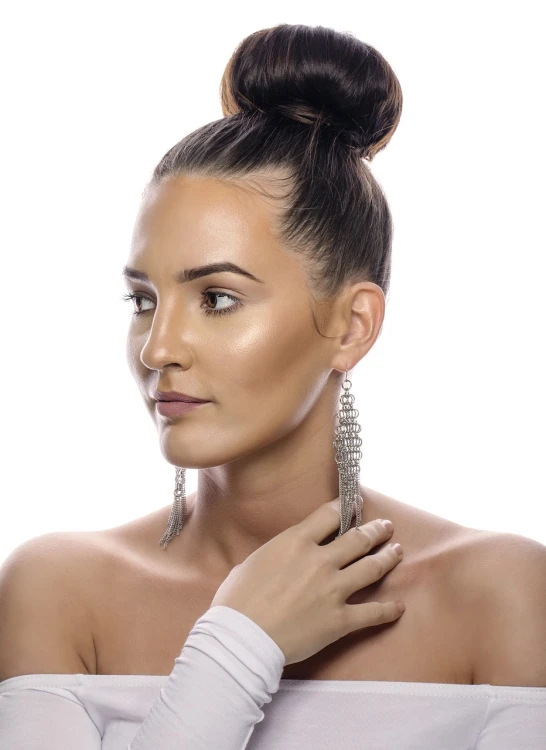 a beautiful woman wearing silver earrings and white dress