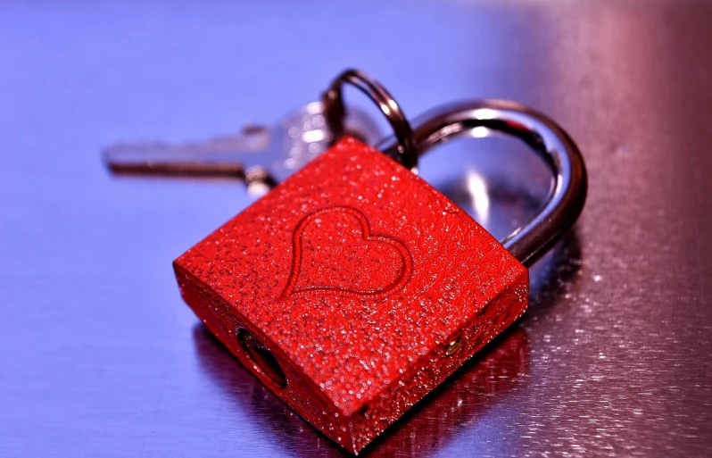 two keys are connected to a red heart shaped object