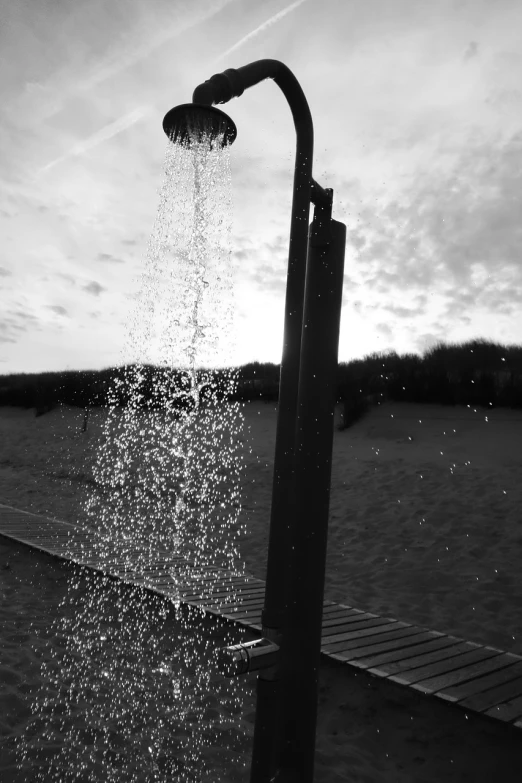 a water faucet on a dock sprinkles water onto the ground