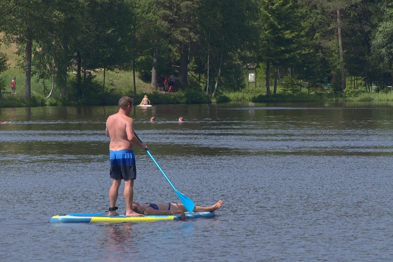 a man paddle boarding with a paddle on the lake