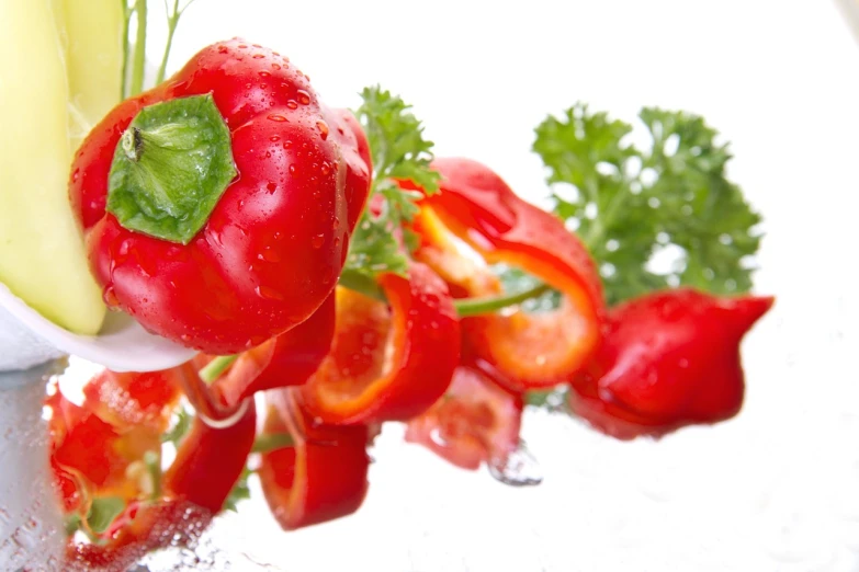 closeup of fresh vegetables being placed on a plate