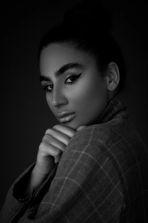 a girl posing in black and white with her hand on her chin