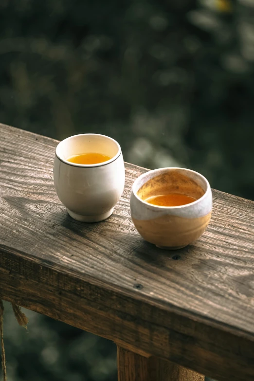 two white bowls sitting on top of a wooden table