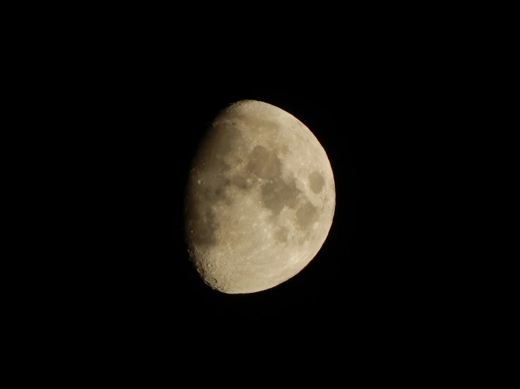 the moon has a dark black sky above it