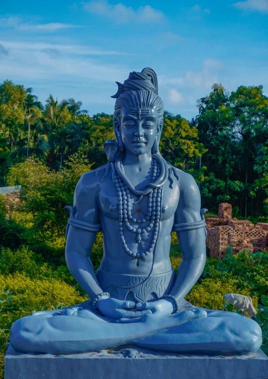 statue of a man doing meditation on a rock