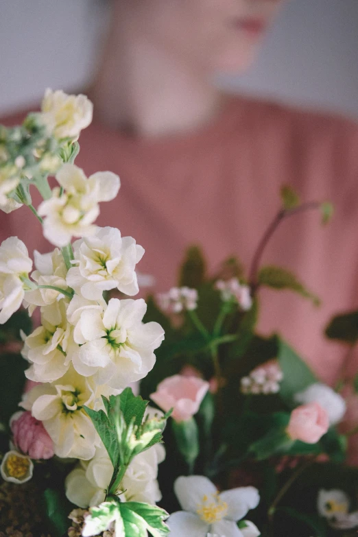 the woman is sitting next to a bouquet of flowers