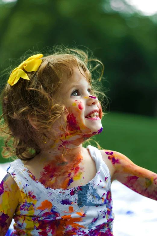 the little girl is covered in colorful food