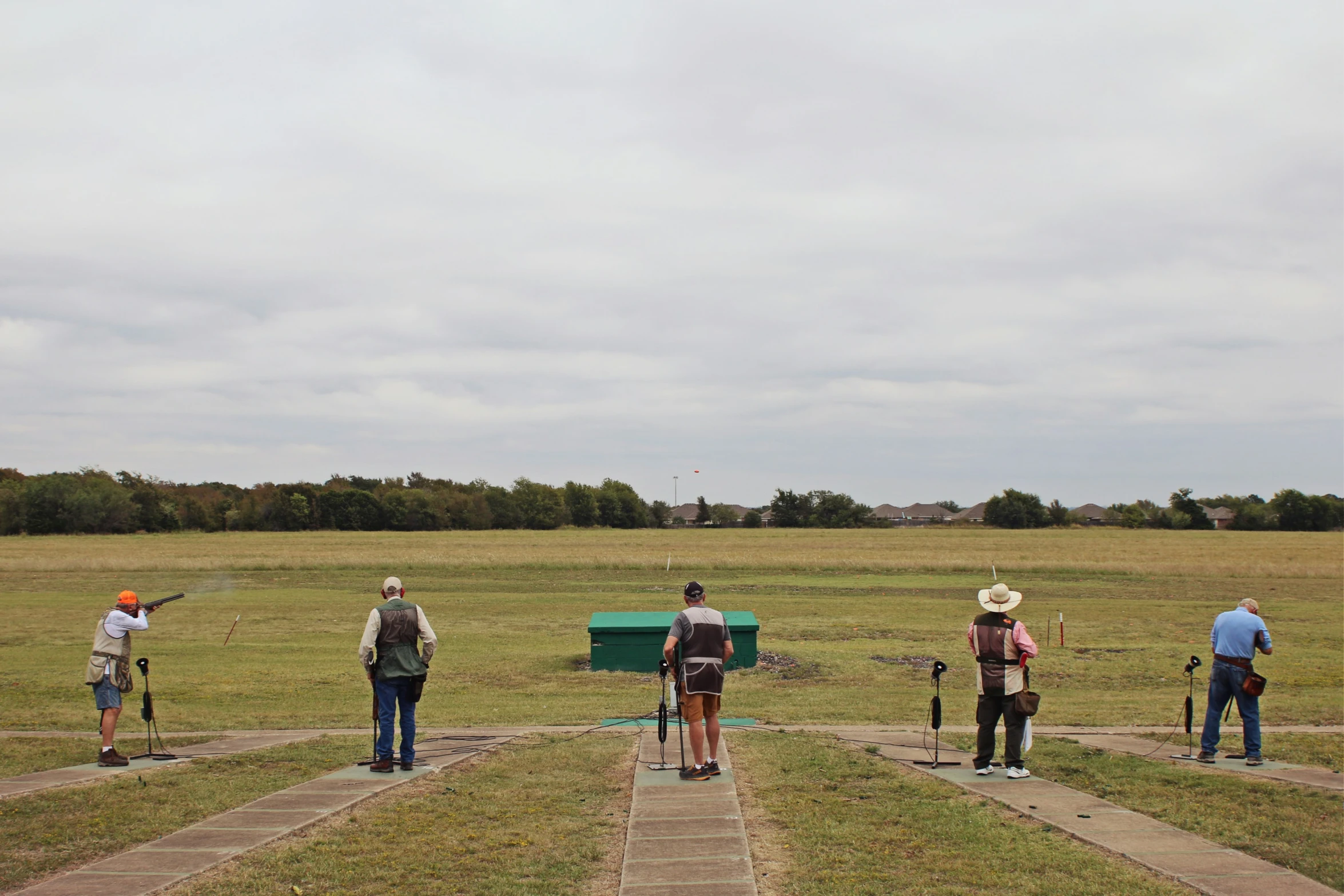 four people with a green wagon with red bags