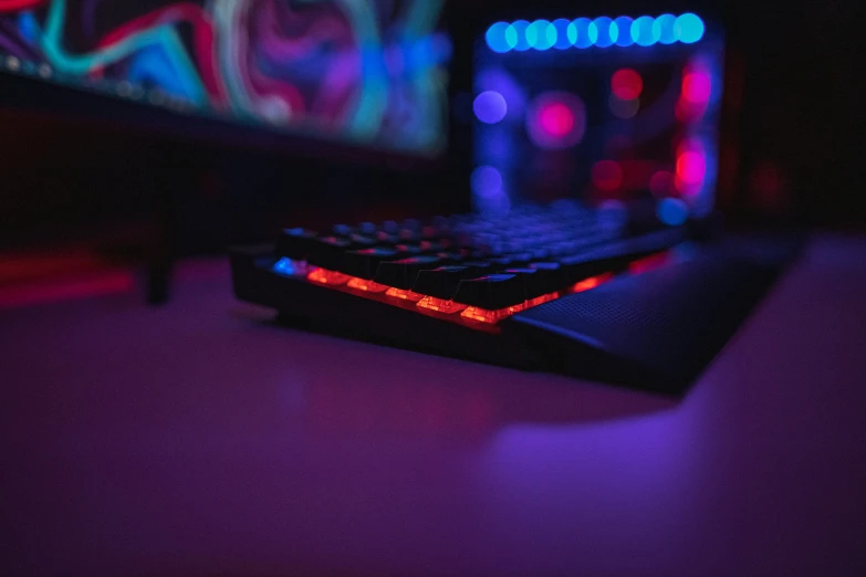 a close up of a computer keyboard with a neon light