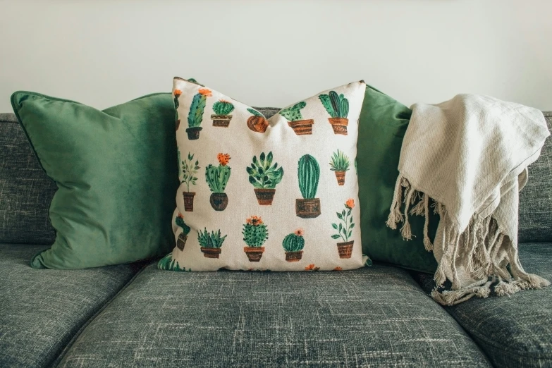 a couch with various cactus pillows sitting on top of it