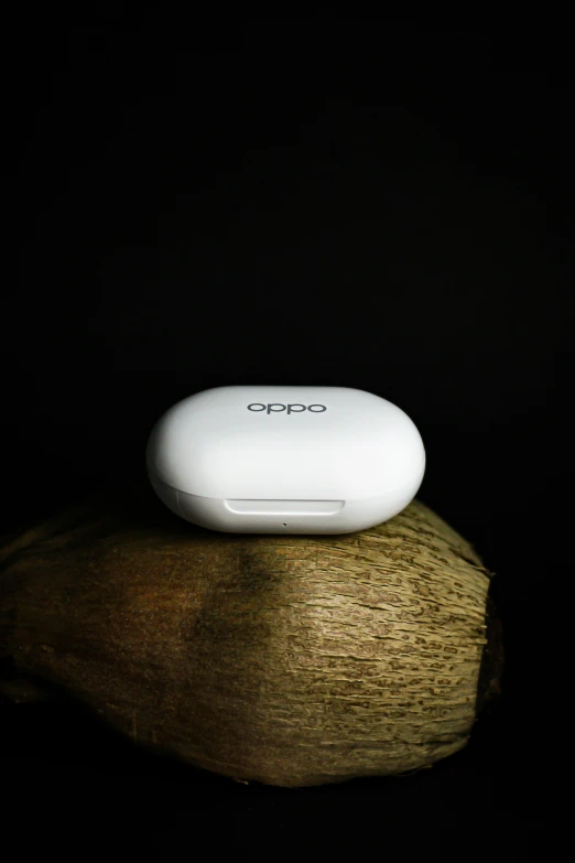 a white remote sitting on top of a piece of wood