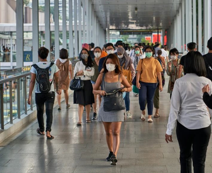 some people wearing masks and walking in an underground space