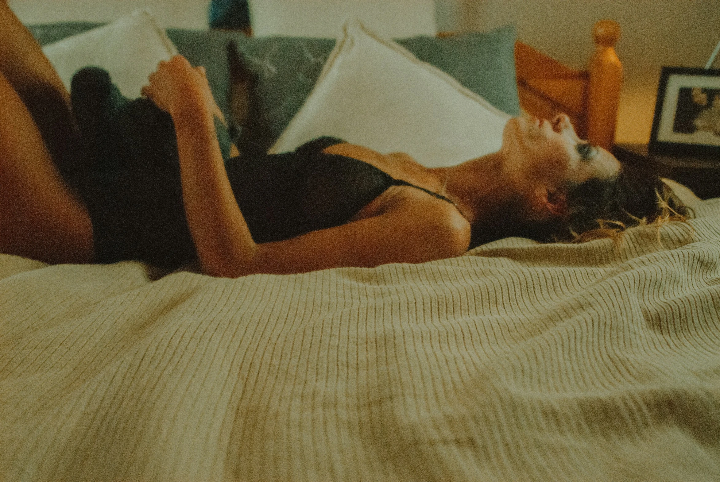 a woman lies on her bed reading a book