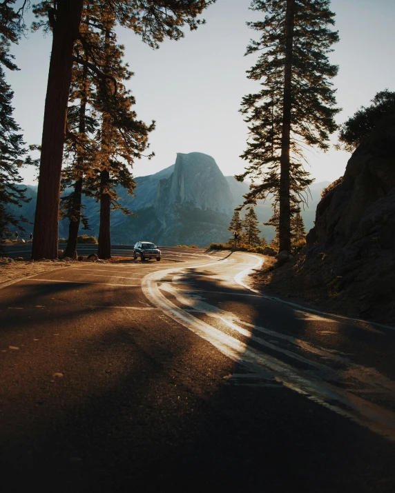 the cars are driving down the road in the sun