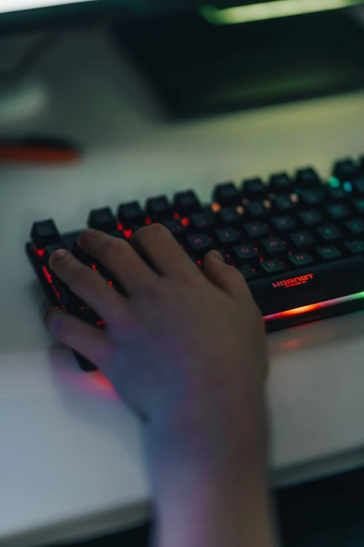 hands typing on a keyboard at night time