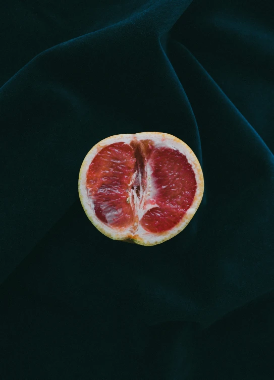 a piece of gfruit on a black surface