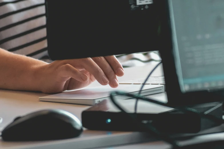 a person's hand on a keyboard on a computer