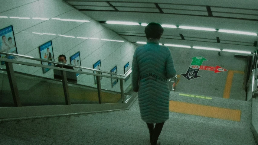 the woman is walking through the tunnel near the doors