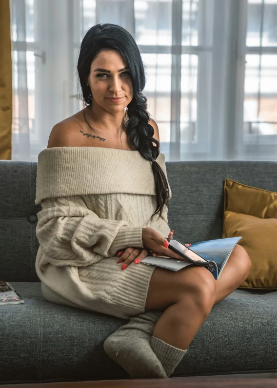 a woman is sitting on a couch with a book