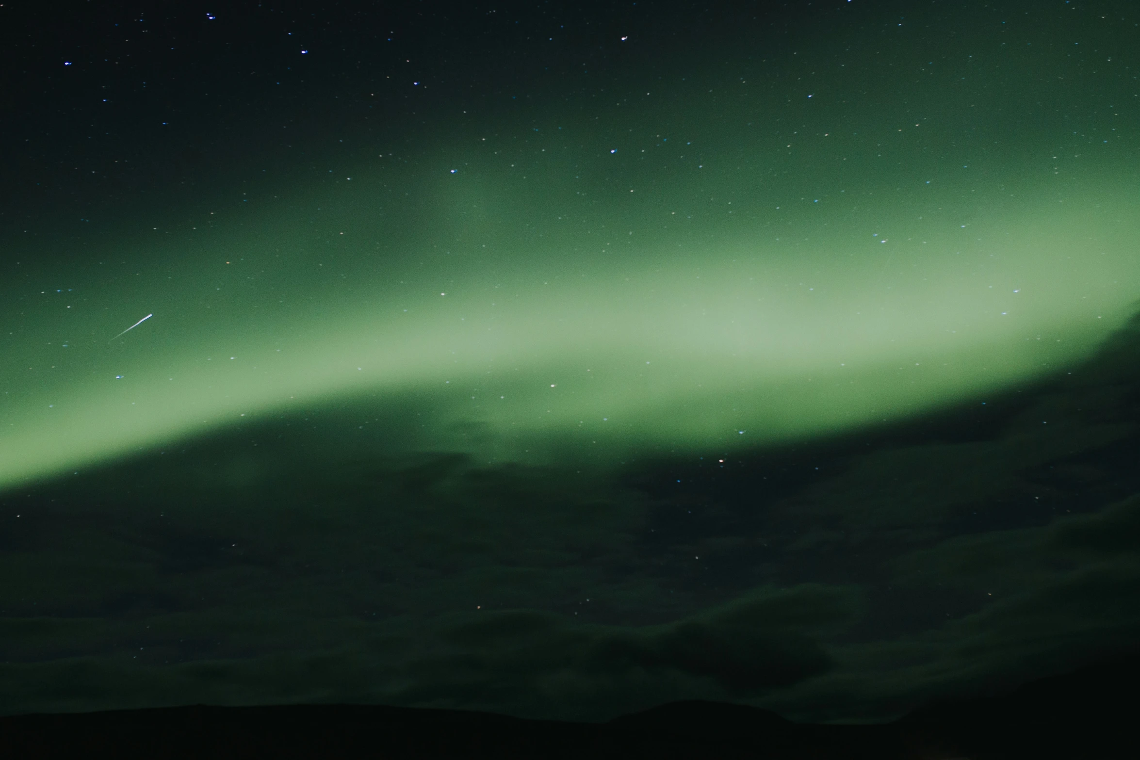 green sky with stars and some white clouds