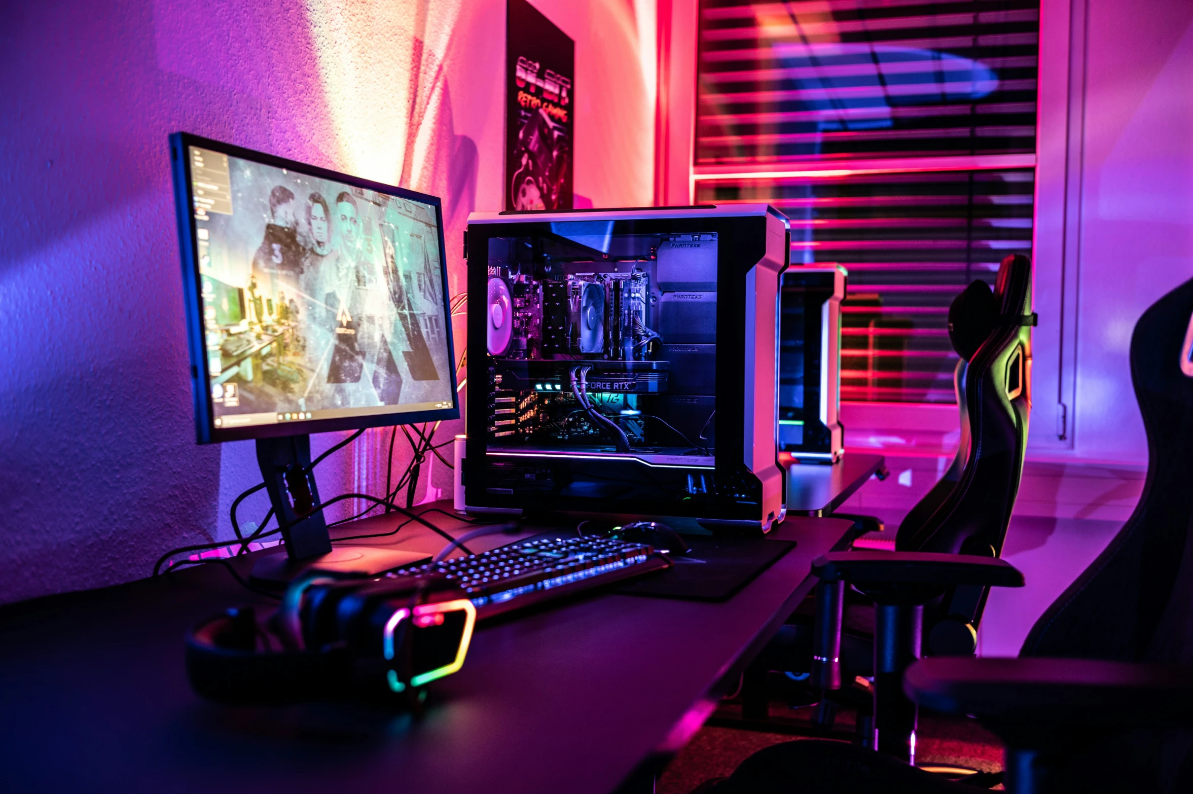 computer monitors are on a desk in front of a window