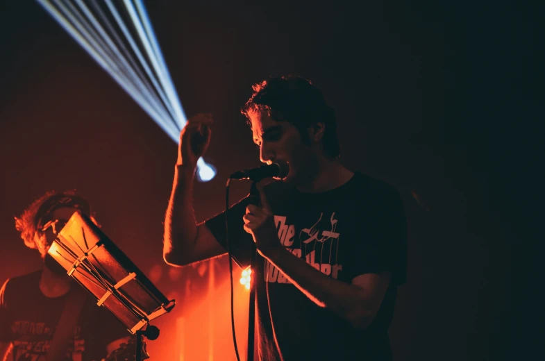 a man standing in front of a microphone on stage