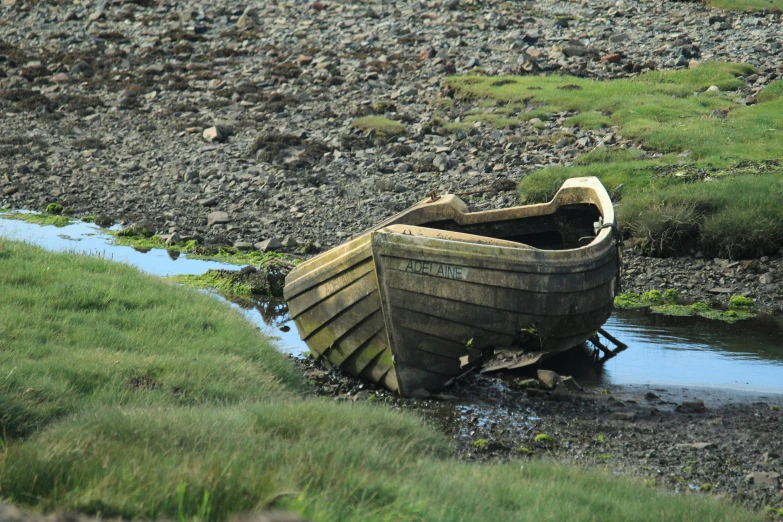 a boat is stuck in the mud by a lake