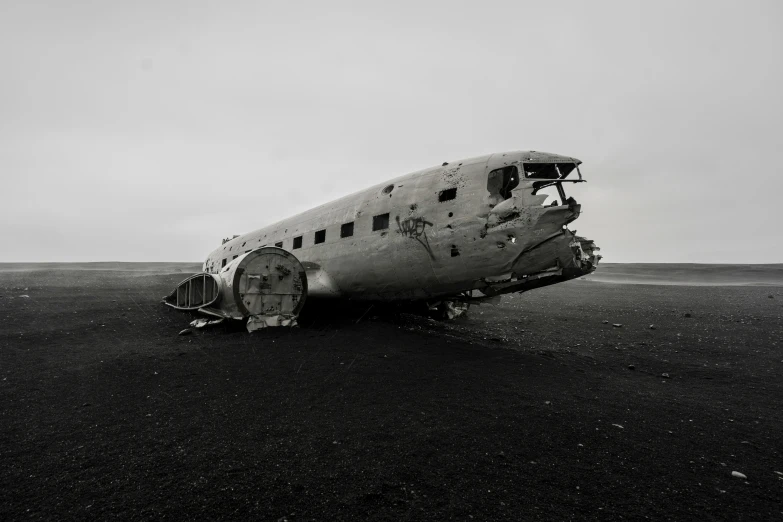 an old plane with a small door and a large broken part sitting in an open area