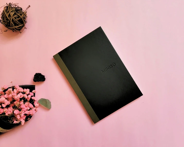 a book sits on top of a table next to flowers