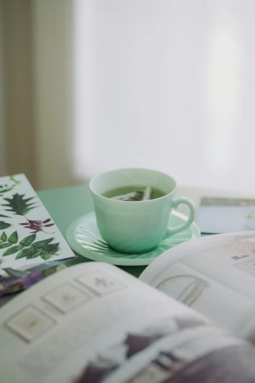 a cup of green tea on an open book