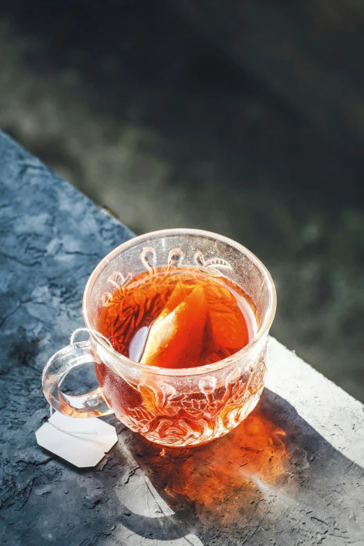 a tea bag sitting on top of a glass cup
