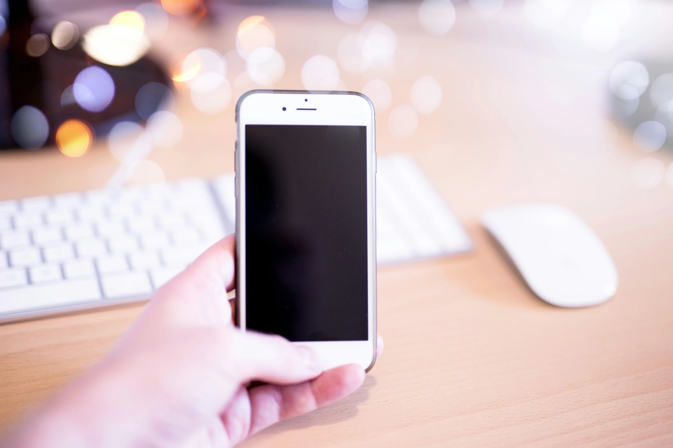 someone holding a cell phone with a white mouse