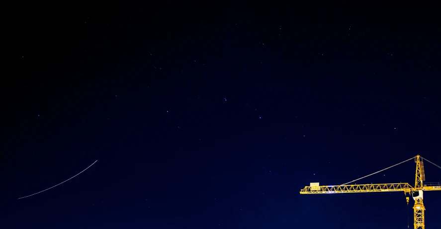 a crane is near the sky with two other cranes on the side