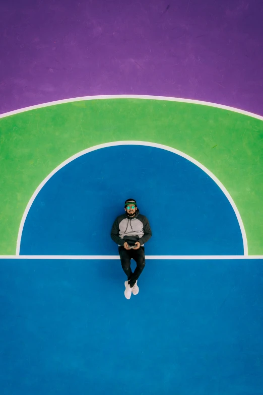 an overhead view of a man sitting on a basketball court