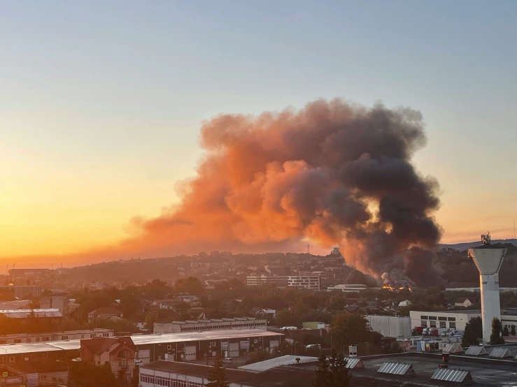 a huge blaze in the sky behind some buildings