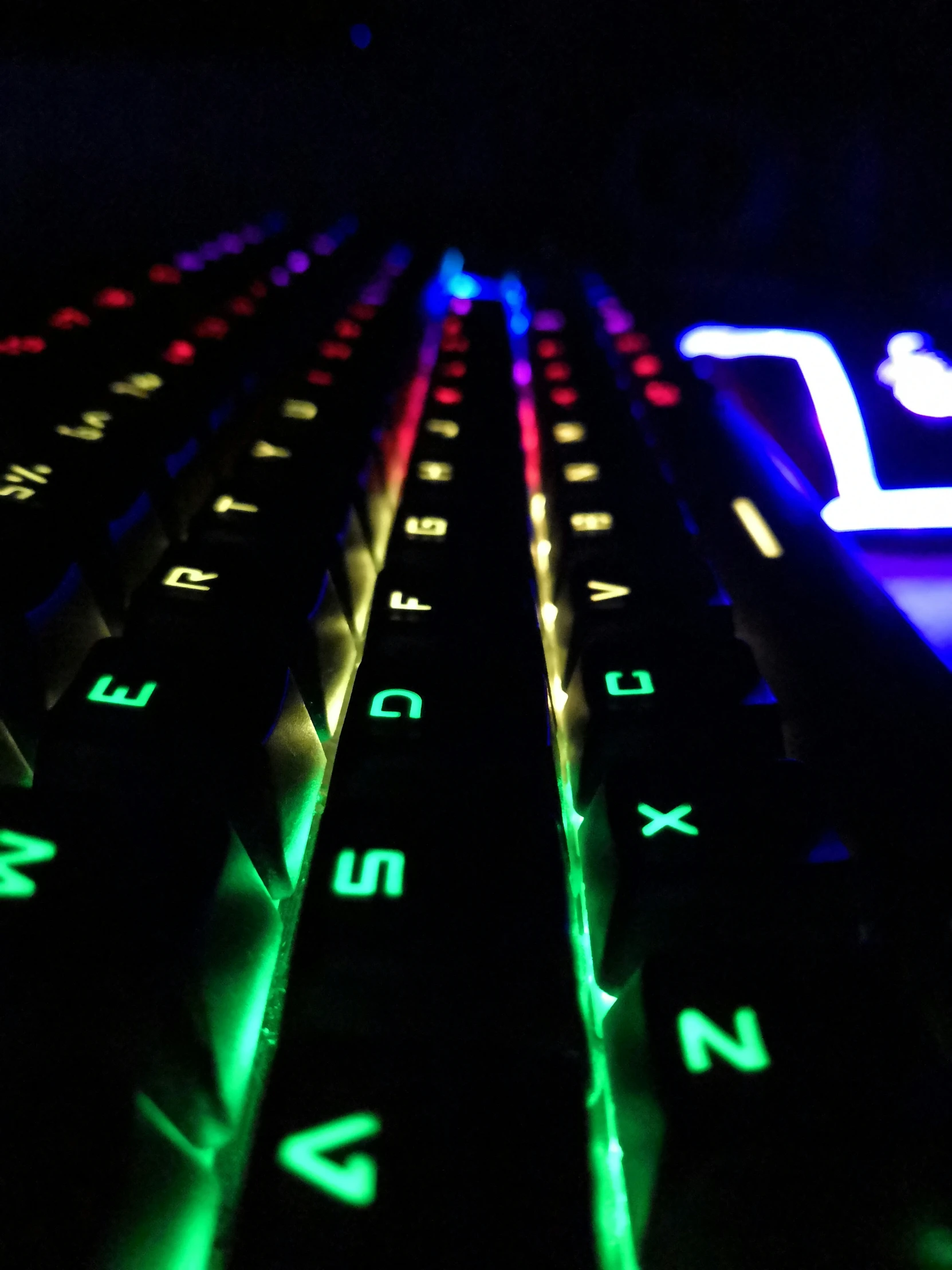 illuminated keyboard with black keys lit up in dark