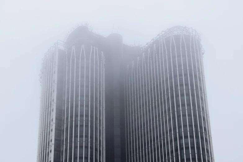 two tall buildings in a foggy city