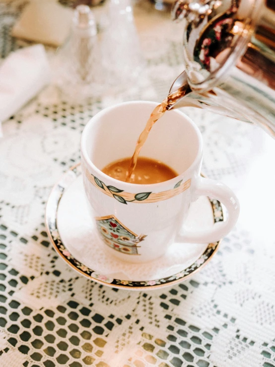 pouring coffee into a coffee cup from a teapot