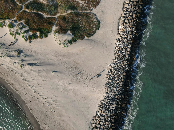 an aerial view of a sandy beach next to water