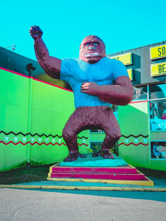 a large statue of a man in a bodysuit standing on a street