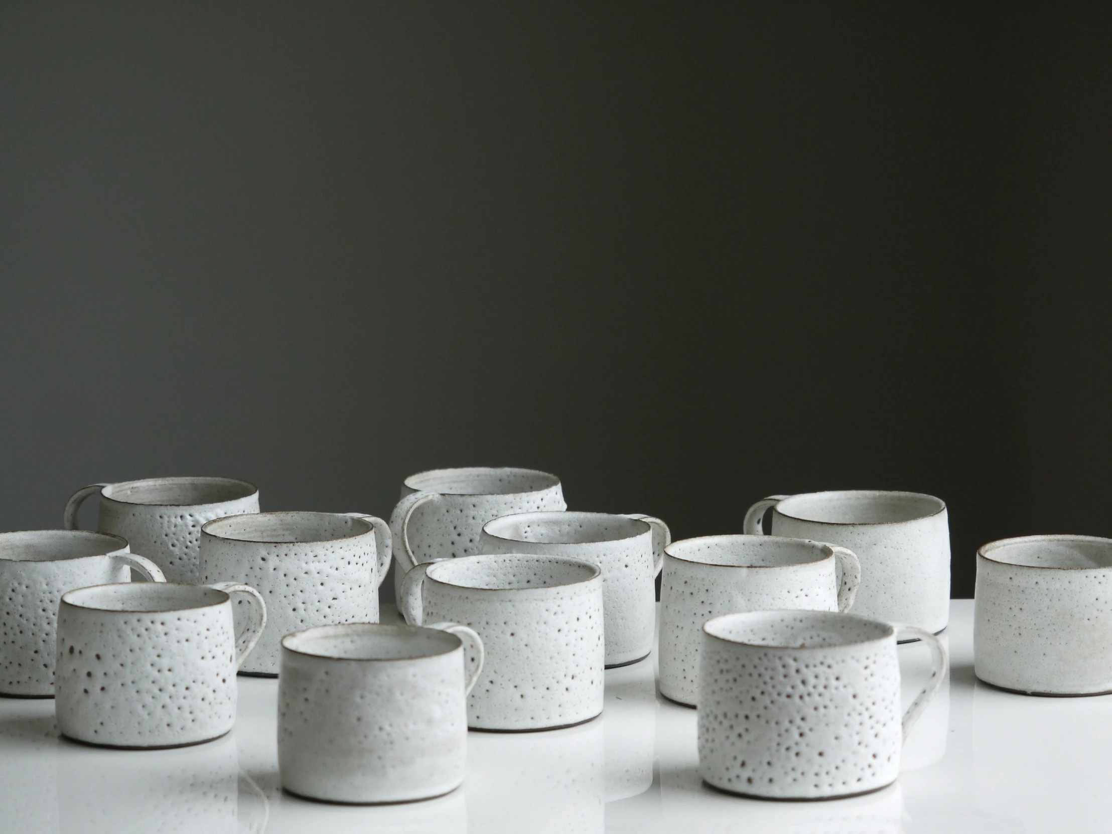 white pottery cups sitting on top of a counter