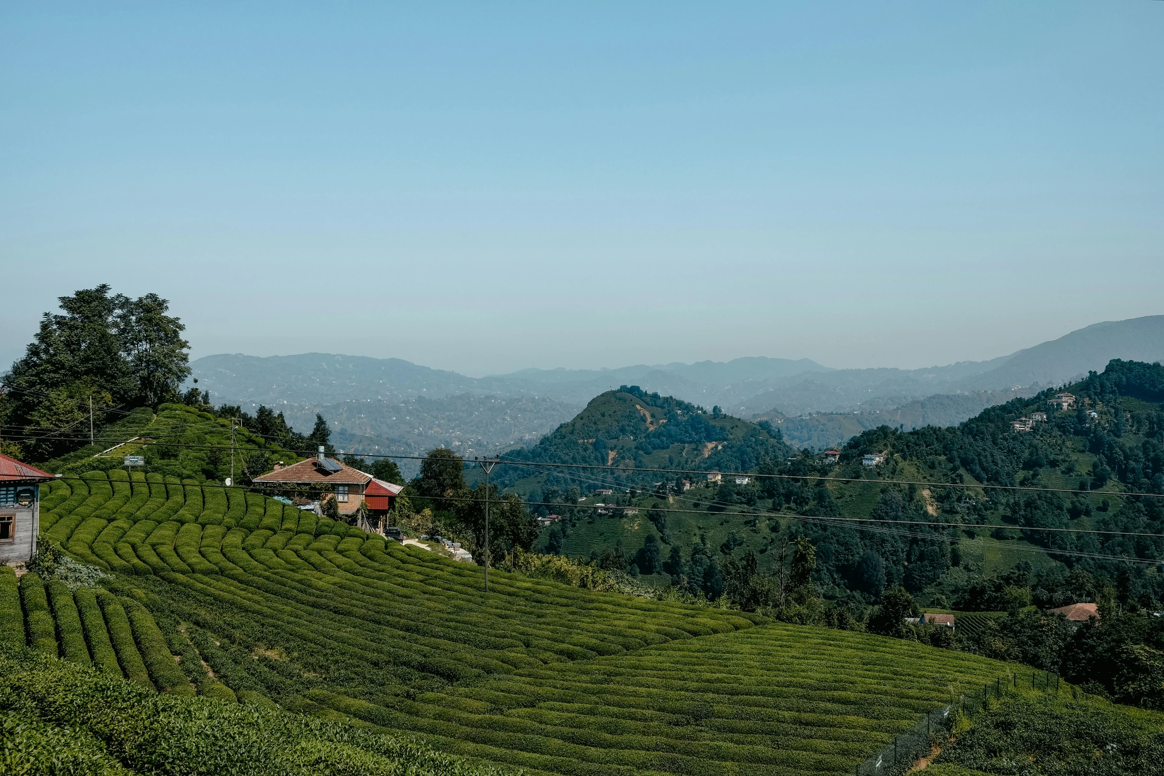 a hillside that has green hills and buildings on it